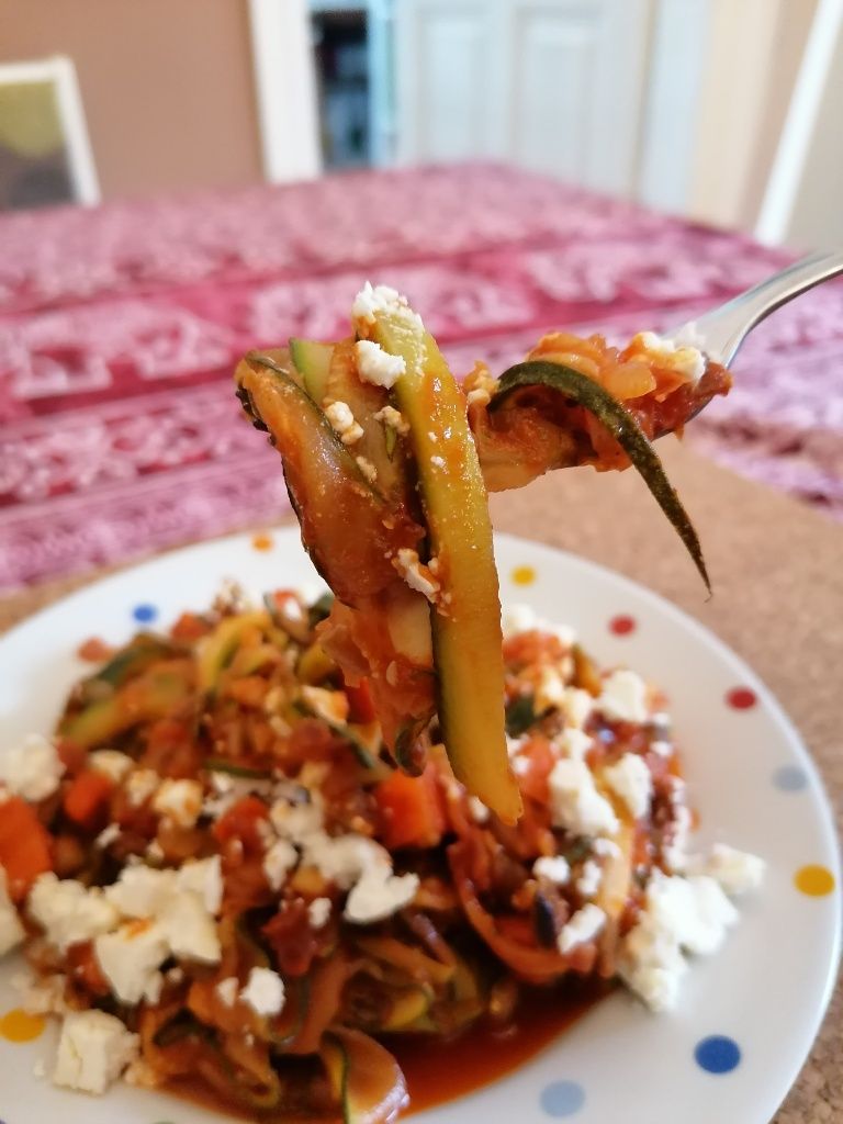 Fertiges Zucchininudelgericht mit Tomaten und Feta angerichtet