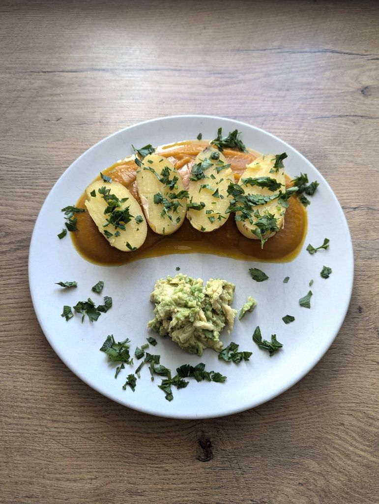 Teller mit Kürbisspiegel, darauf gekochte Erdäpfeln und Avocadodip. Alles mit gehackter Petersilie bestreut