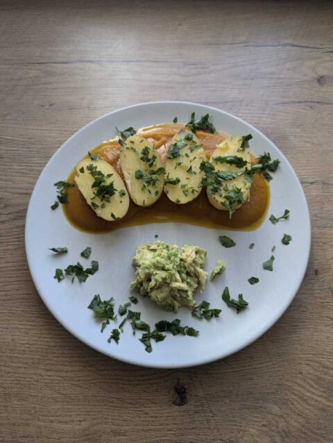 Teller mit Kartoffeln auf Kürbispüree